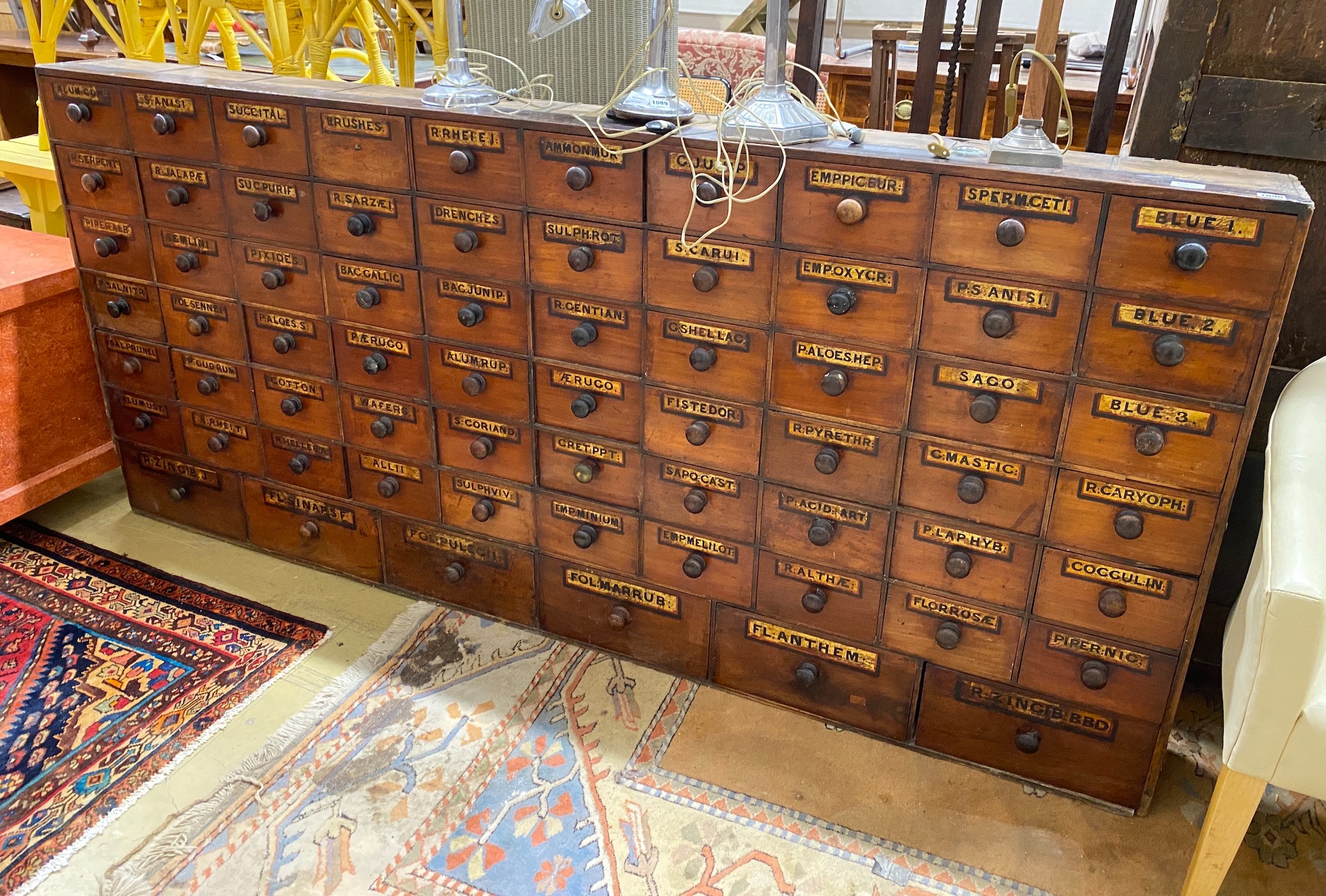 A 19th century mahogany and pine 66 drawer apothecary chest with turned wood handles and some later painted detail, length 227cm, depth 20cm, height 102cm
